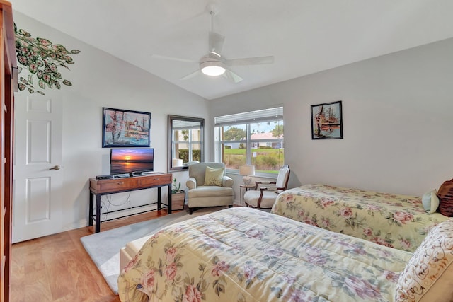 bedroom featuring ceiling fan, light hardwood / wood-style floors, and lofted ceiling