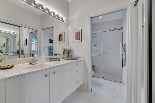 bathroom with tile patterned flooring, vanity, and a shower with shower door