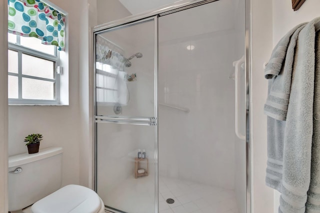 bathroom with an enclosed shower and toilet