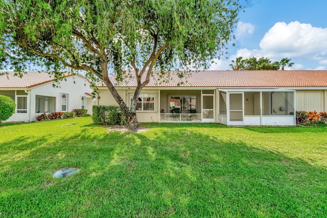 back of house with a lawn and a sunroom