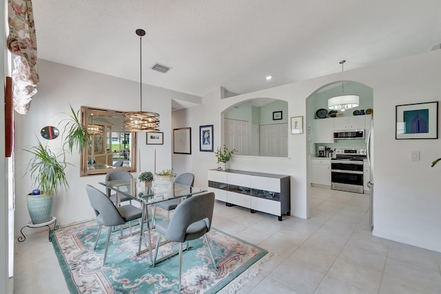 tiled dining area with a textured ceiling