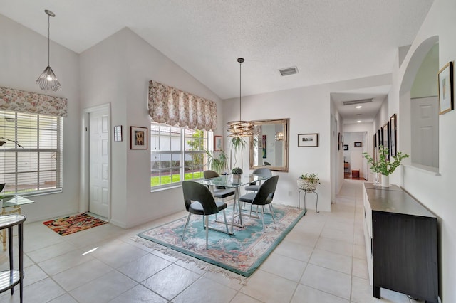 dining space featuring plenty of natural light, light tile patterned floors, and a textured ceiling