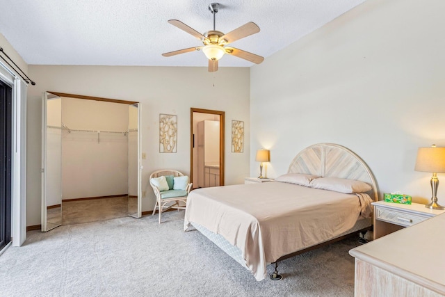 bedroom with ceiling fan, a closet, lofted ceiling, and light colored carpet