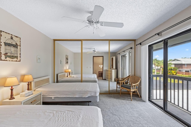 bedroom featuring a closet, ceiling fan, access to exterior, carpet, and a textured ceiling
