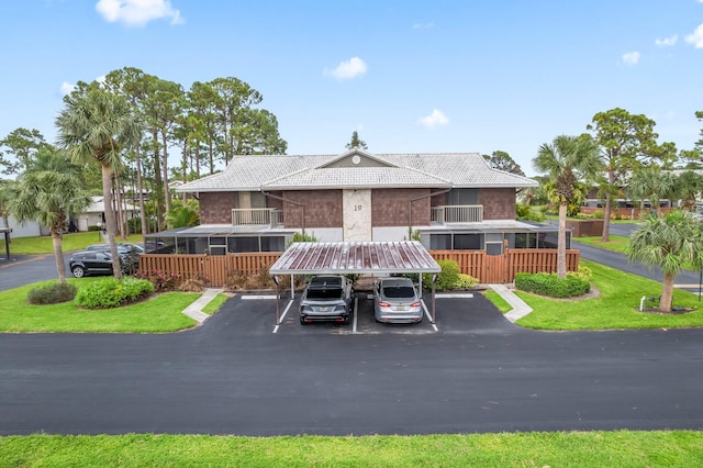 view of property featuring covered and uncovered parking