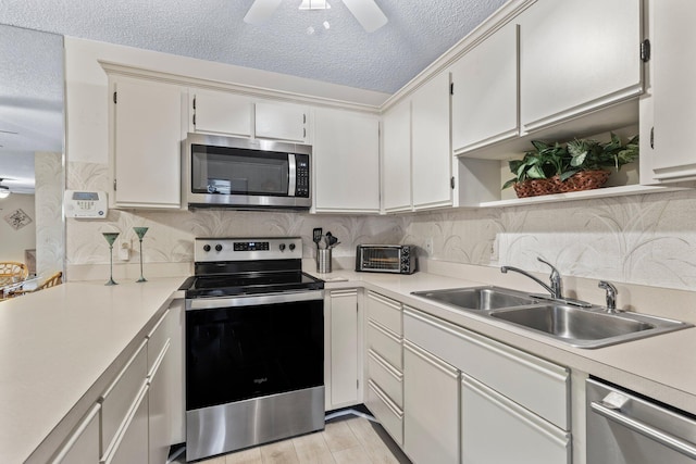 kitchen with light hardwood / wood-style floors, white cabinetry, sink, and appliances with stainless steel finishes