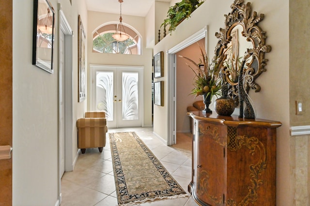 tiled foyer with french doors and a high ceiling