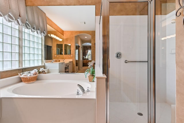 bathroom featuring plus walk in shower and vanity