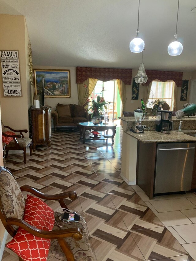 kitchen with stone counters, dishwasher, hanging light fixtures, and tile patterned flooring