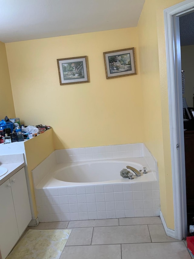 bathroom with tile patterned flooring, vanity, and tiled tub