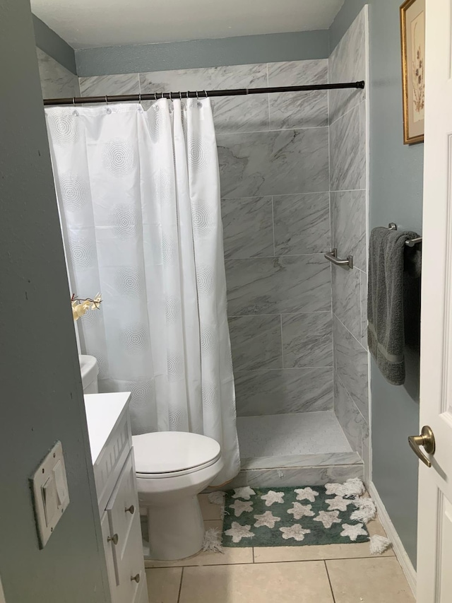 bathroom with tile patterned floors, vanity, toilet, and walk in shower