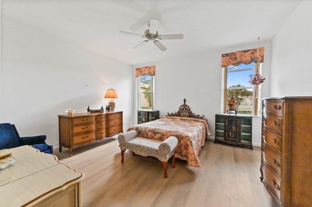 bedroom featuring light wood-type flooring, multiple windows, and ceiling fan