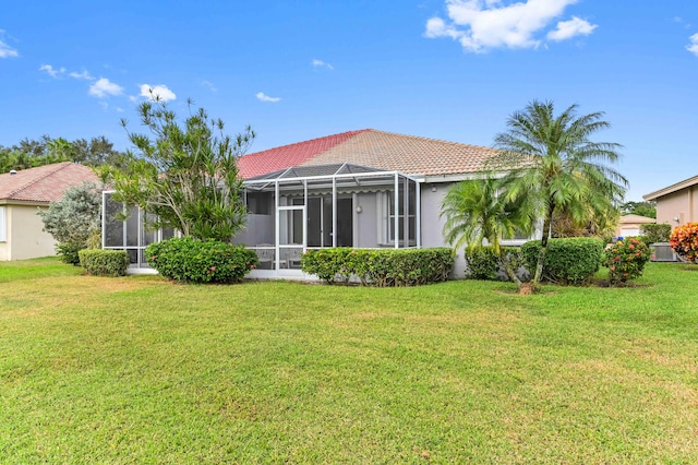 rear view of house featuring a lawn and a lanai