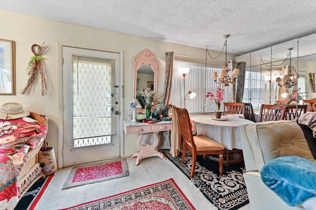 dining room featuring carpet, a textured ceiling, and a chandelier