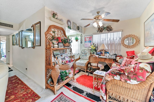 living room with ceiling fan, light colored carpet, and a textured ceiling