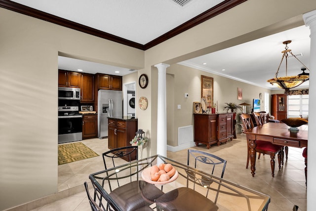 tiled dining room featuring stacked washer and dryer, ornate columns, and crown molding