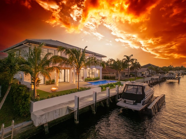 dock area featuring a patio, a water view, and a community pool