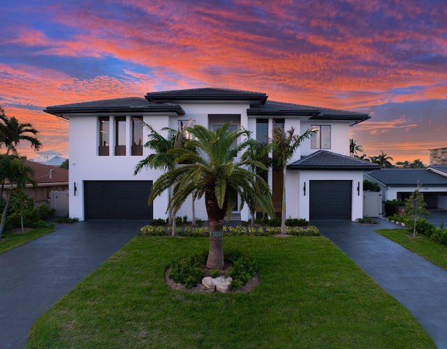 view of front of property with a front yard, driveway, and stucco siding