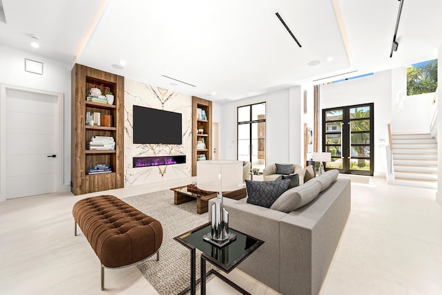 living area featuring visible vents, stairway, french doors, built in shelves, and a fireplace