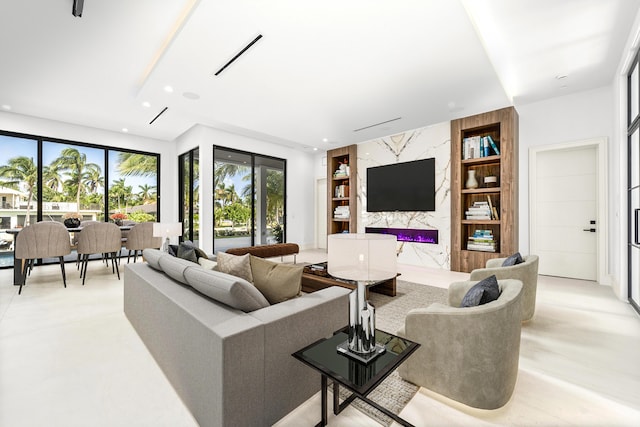 living area with a high end fireplace, an accent wall, visible vents, and recessed lighting