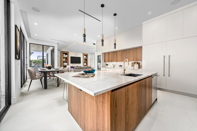 kitchen with white cabinets, modern cabinets, a sink, a large island with sink, and stainless steel dishwasher