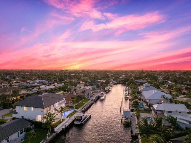 aerial view at dusk with a residential view and a water view