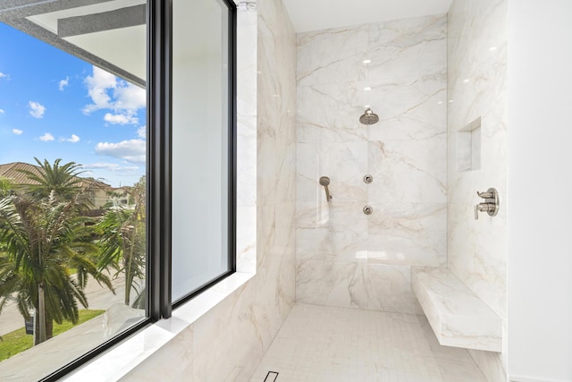 bathroom with a healthy amount of sunlight and a marble finish shower