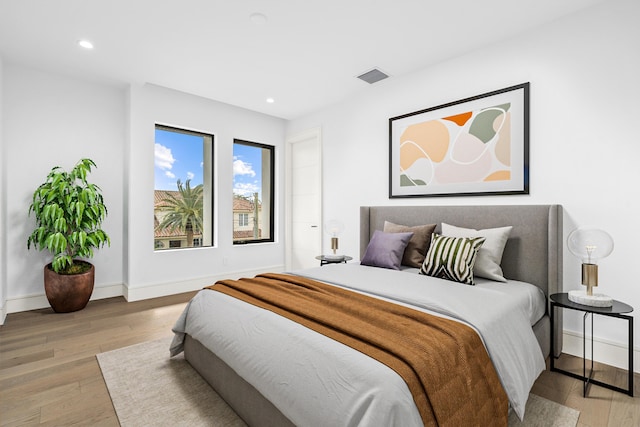 bedroom featuring baseboards, visible vents, wood finished floors, and recessed lighting