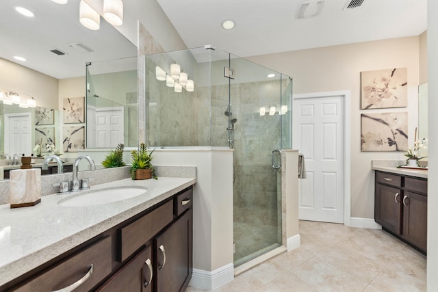 bathroom featuring tile patterned floors, vanity, and a shower with door