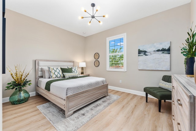 bedroom with a chandelier and light hardwood / wood-style flooring