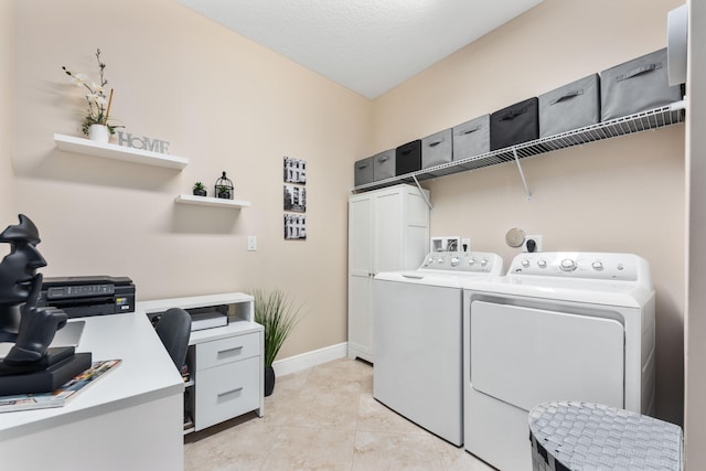 clothes washing area with cabinets, light tile patterned floors, a textured ceiling, and washing machine and dryer