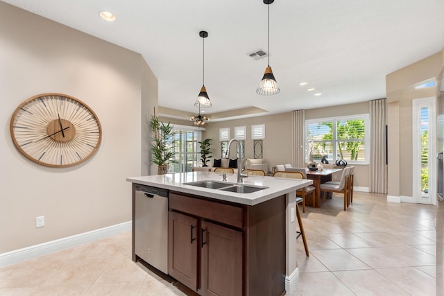 kitchen with dishwasher, a center island with sink, sink, hanging light fixtures, and dark brown cabinetry