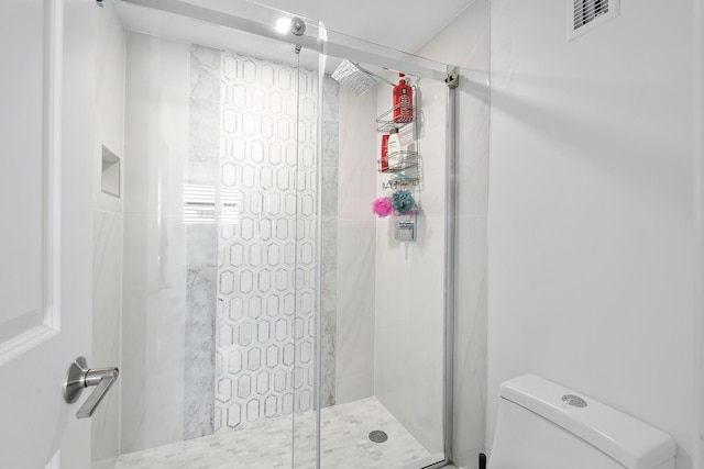 bathroom featuring walk in shower and toilet