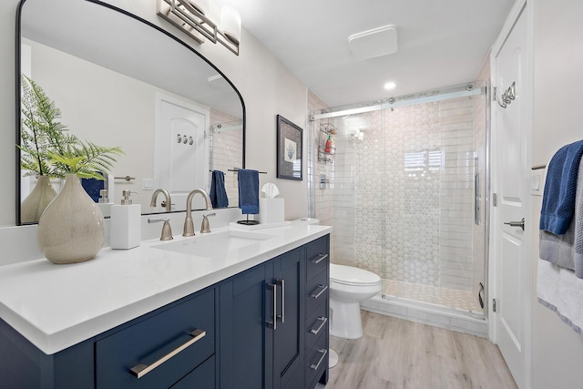 bathroom featuring walk in shower, hardwood / wood-style floors, vanity, and toilet