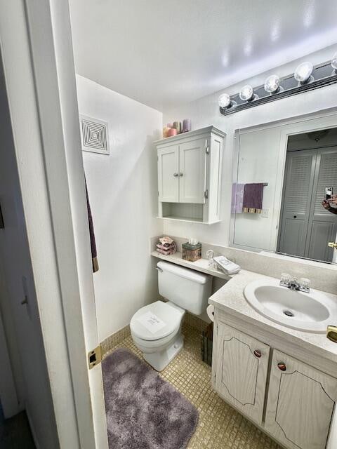 bathroom featuring toilet, vanity, and tile patterned floors