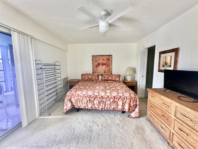 carpeted bedroom with a textured ceiling and ceiling fan