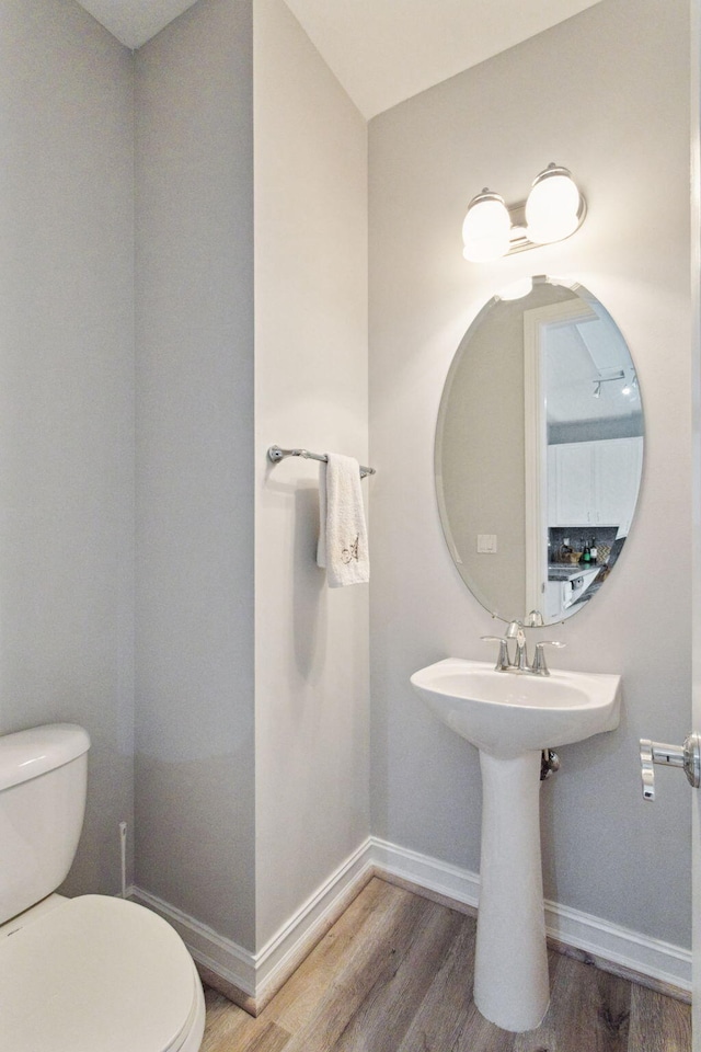 bathroom featuring hardwood / wood-style flooring and toilet