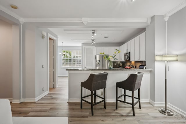 112 W Coda Cir, Delray Beach, FL 33444 - kitchen with stainless steel appliances, a breakfast bar, white cabinetry, light wood-style flooring, and ornamental molding