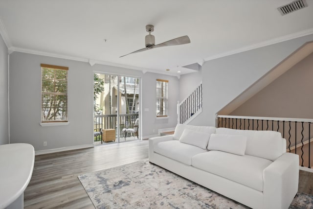 living room with ceiling fan, wood-type flooring, and ornamental molding