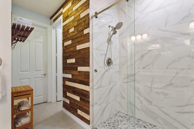 bathroom with wooden walls, tile patterned flooring, and walk in shower