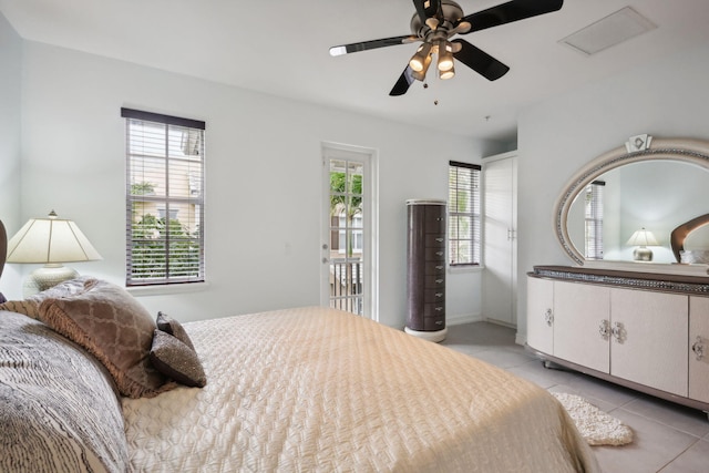 bedroom featuring multiple windows, light tile patterned floors, access to outside, and ceiling fan