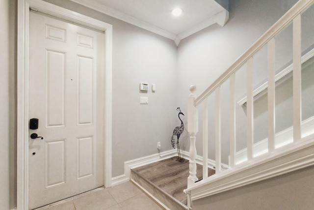 foyer with light tile patterned flooring and ornamental molding