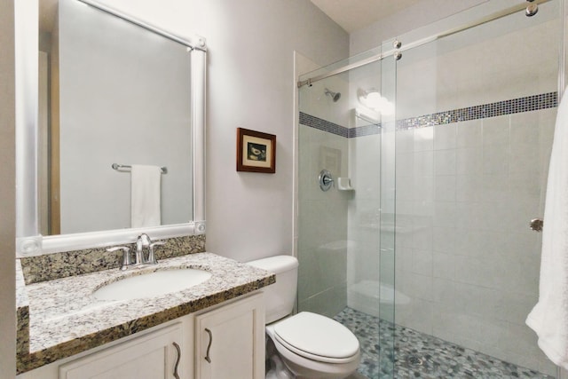 bathroom with vanity, toilet, and a shower with door