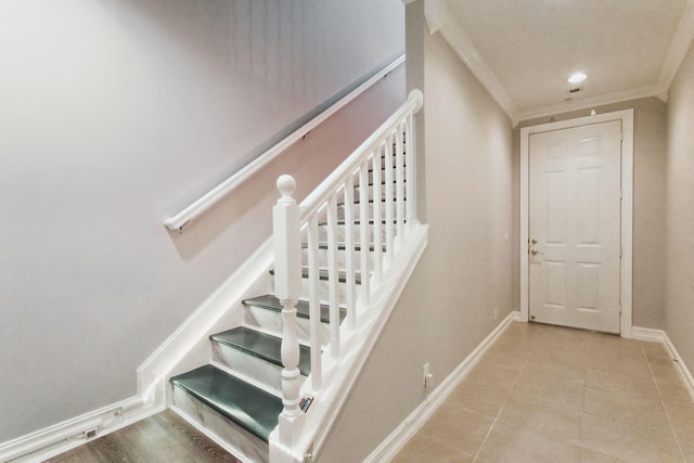 staircase featuring tile patterned floors and crown molding