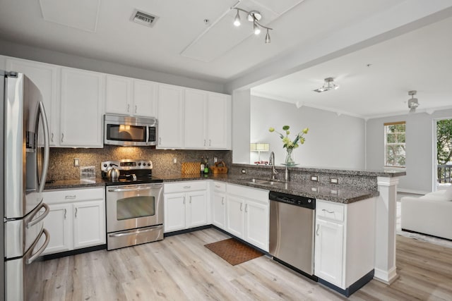 kitchen with white cabinets, sink, light hardwood / wood-style flooring, appliances with stainless steel finishes, and kitchen peninsula