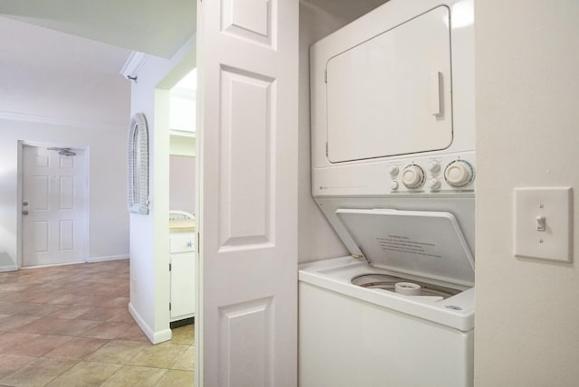 laundry room with stacked washer and dryer and light tile patterned floors