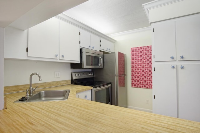 kitchen featuring sink, stainless steel appliances, a textured ceiling, white cabinets, and ornamental molding