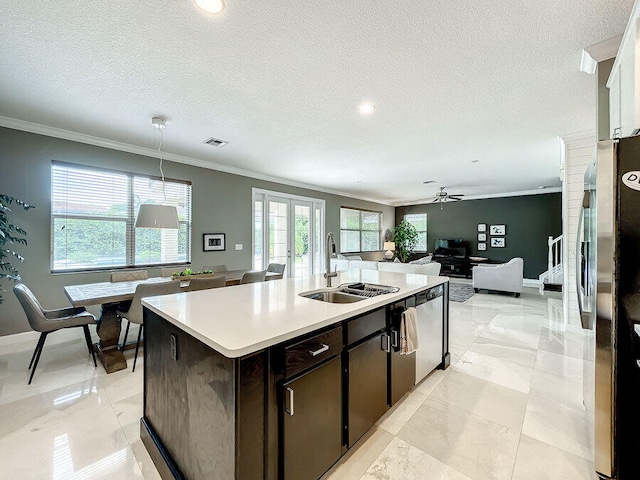 kitchen with stainless steel appliances, sink, decorative light fixtures, an island with sink, and dark brown cabinets