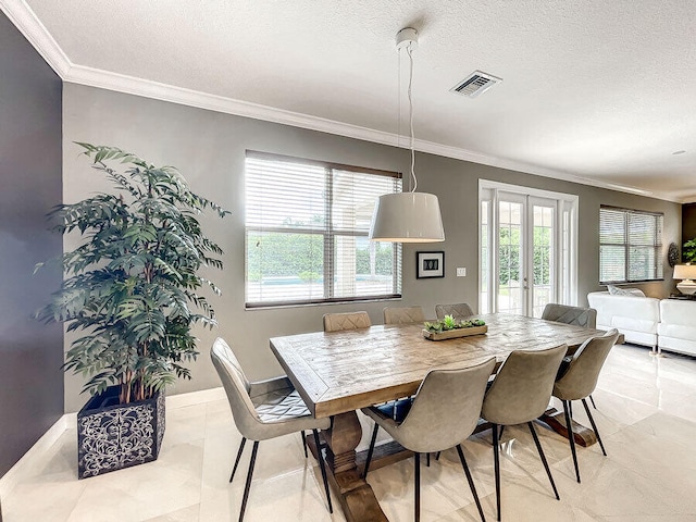 dining room with a textured ceiling, french doors, a healthy amount of sunlight, and crown molding