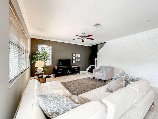 living room featuring ceiling fan, a textured ceiling, and crown molding